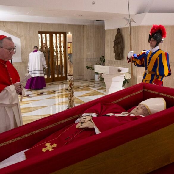 Vatican Secretary of State Cardinal Pietro Parolin, left, prays in front of the body of Pope Francis laid out in state inside his private chapel at the Vatican, Monday, April 21, 2025. (Vatican Media via AP, HO)